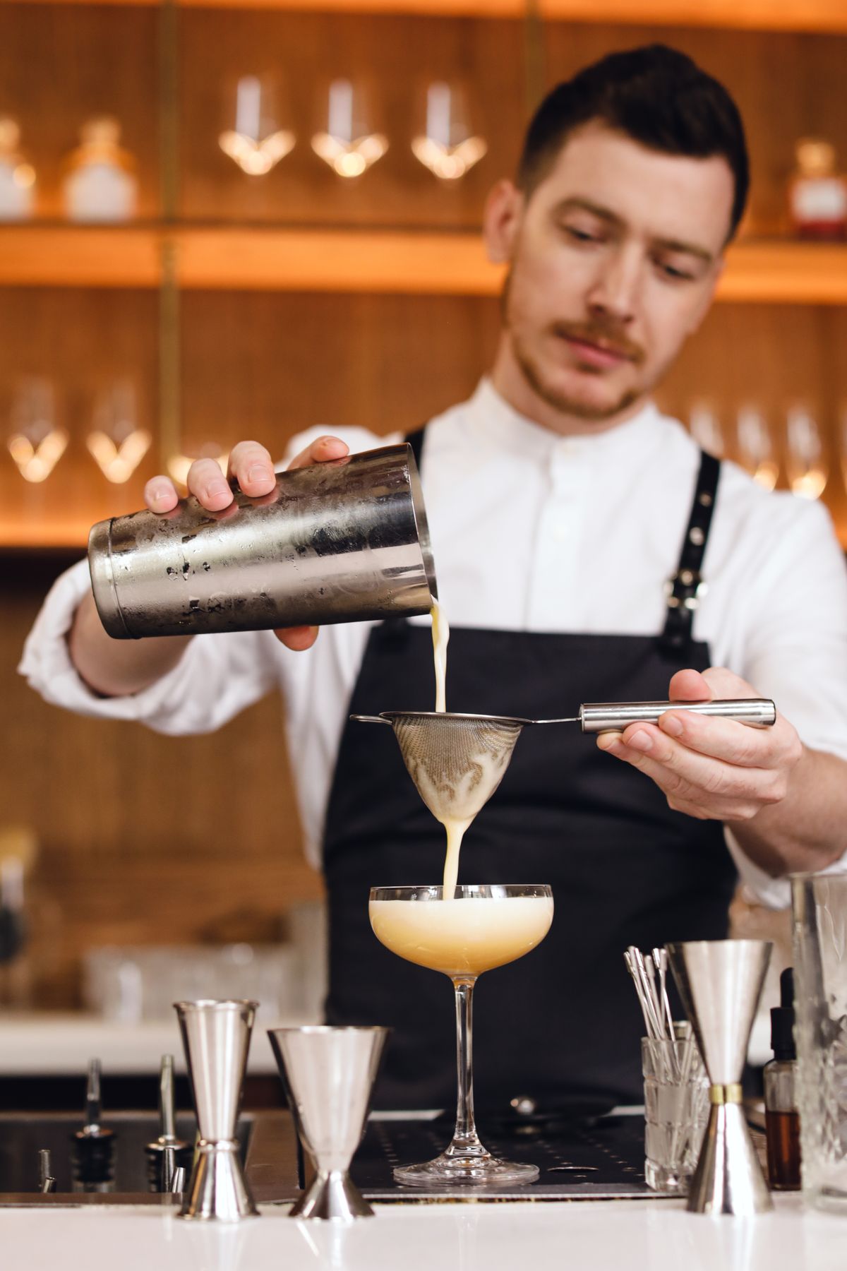 Barman filtrant un cocktail artisanal